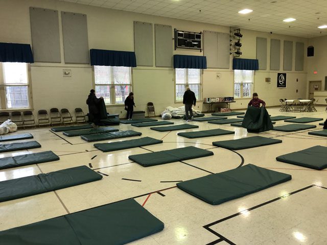 Sleeping mats set out in a church gym.