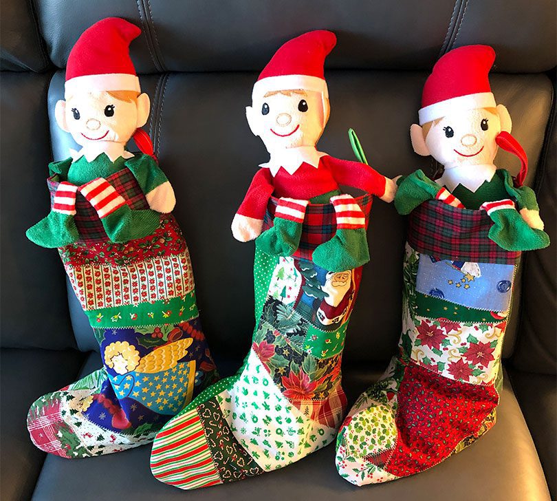 three handmade stockings with elves inside